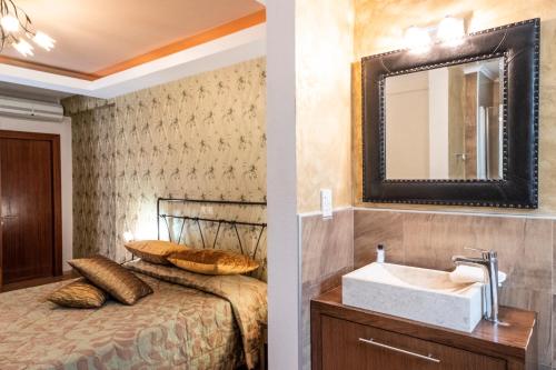a bathroom with a bed with a sink and a mirror at Country Inn in Kallithea Halkidikis