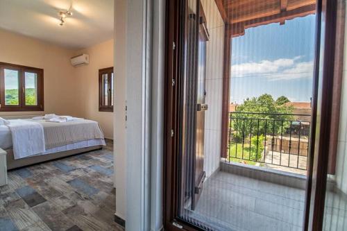 ein Schlafzimmer mit einem Bett und einem großen Fenster in der Unterkunft Villa Clairy in Argalasti, Pelion in Argalasti