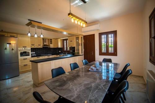 a large kitchen with a dining table and chairs at Villa Clairy in Argalasti, Pelion in Argalasti