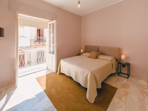 een slaapkamer met een bed en een groot raam bij FICU PALACE in Siracusa