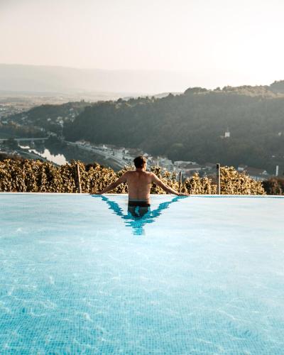 a man in a swimming pool with his arms outstretched at Tri lučke Hotel & Restaurant in Krško