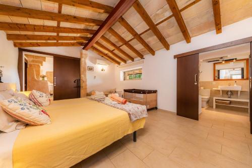 a bedroom with a large bed and a bathroom at Es Rafalet - Es Porxet in Manacor