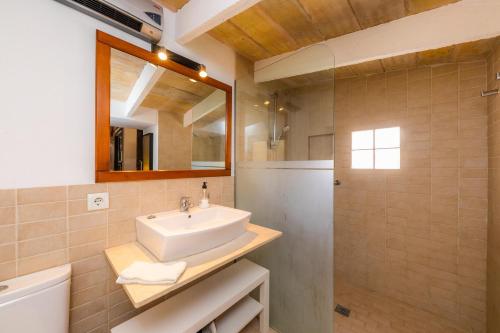 a bathroom with a sink and a mirror and a toilet at Es Rafalet - Es Porxet in Manacor