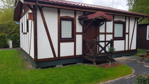 a tiny house with a roof on a yard at Pustkowo Domki Wakacyjne u Marka in Pustkowo