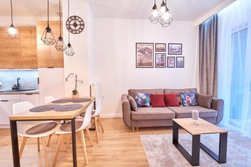 uma sala de estar com um sofá e uma mesa em LAGUNA Apartament Polanica Residence 2 em Polanica-Zdrój