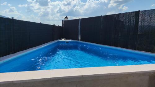 a swimming pool in front of a black fence at Casa Rural Idesign in Villanueva de Ávila