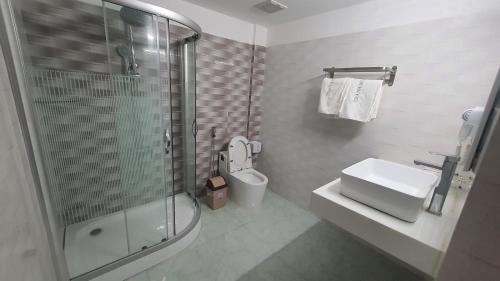 y baño con ducha, aseo y lavamanos. en Thành Mỹ Hotel, en Cam Ranh