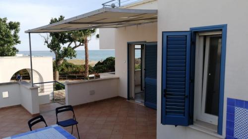 balcone con persiane blu e vista sull'oceano di SPELU - Appartamento con terrazza fronte mare a Lido Marini