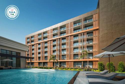 een hotel met een zwembad voor een gebouw bij Mandarin Eastville, Pattaya - SHA Extra Plus in Noord Pattaya