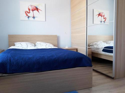 a bedroom with a bed and a mirror at Apartament Imagus Oliwa in Gdańsk