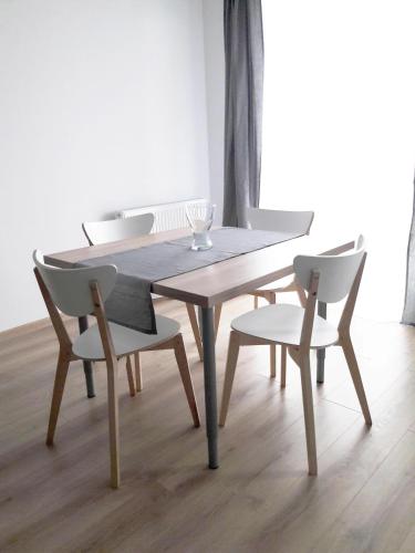 a wooden table and chairs in a dining room at Apartament Imagus Oliwa in Gdańsk