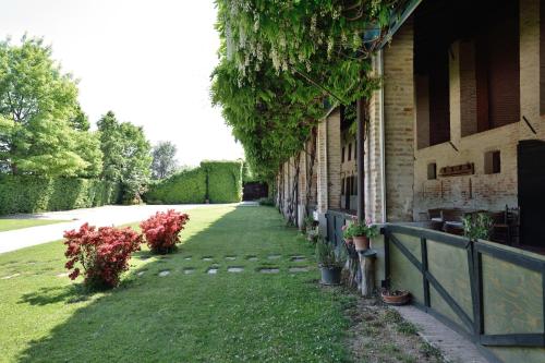 a building with a fence and some plants and flowers at Tenuta Le Risare in Campo San Martino