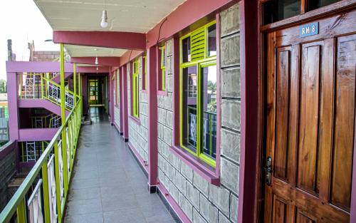 a hallway of a building with colorful walls and doors at Kimana Omega Safari Lodge in Kimana