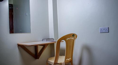 a wooden desk with a chair and a mirror at Kimana Omega Safari Lodge in Kimana