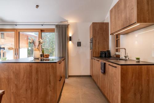 a kitchen with wooden cabinets and a counter top at Luxury Chalets Gradenbach near Schladming in Haus im Ennstal