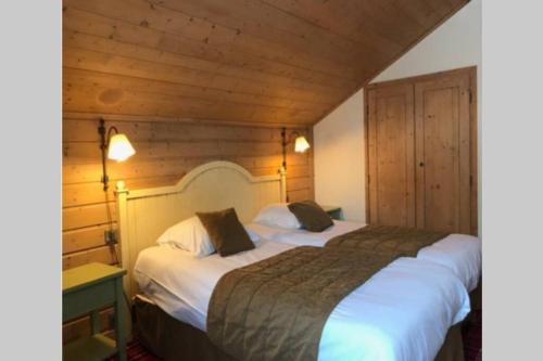 two beds in a hotel room with wooden walls at ARC 1950 - Hameau du Glacier appartement duplex 8 pers in Arc 1950