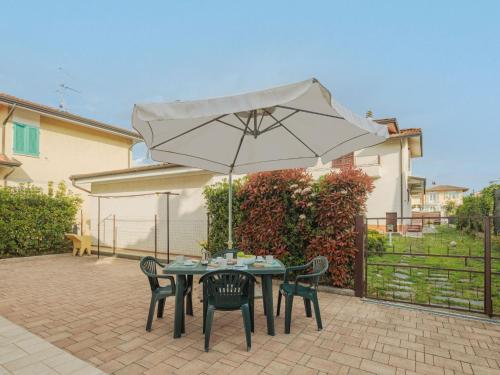 a table and chairs with an umbrella on a patio at Holiday Home Manuela by Interhome in Marina di Pietrasanta