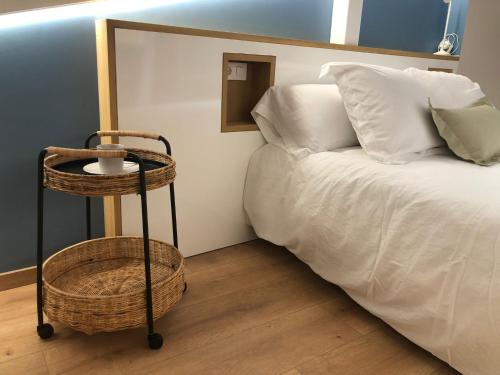 a bedroom with a bed and a basket next to a table at Apartamento completamente equipado en Pontedeume. in Puentedeume