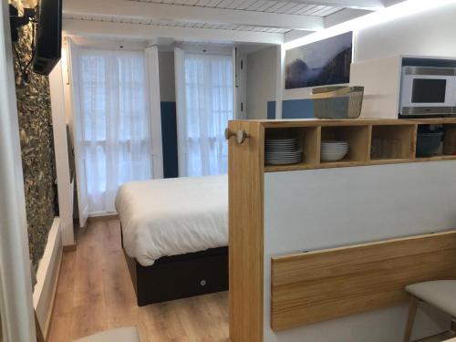 a small bedroom with a bed and a microwave at Apartamento completamente equipado en Pontedeume. in Puentedeume