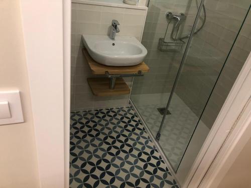 a bathroom with a sink and a glass shower at Apartamento completamente equipado en Pontedeume. in Puentedeume
