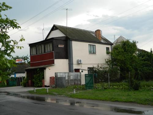 una casa bianca e nera sul lato di una strada di Готель АРГО a Khrystynivka