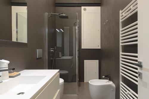Un baño con inodoro, lavabo y ducha. en La Terrazza sul Parco Suite, en LʼAquila