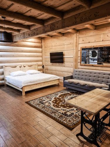 a bedroom with a bed and a couch and a tv at Apartamenty Góralski DACH NAD GŁOWĄ in Poronin