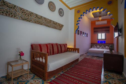 a living room with a couch and a tv at Hotel Casa Miguel in Chefchaouene
