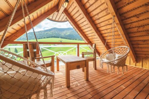 a porch with a hammock and a table and chairs at Salaš Syrex in Zázrivá