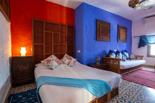 um quarto com 2 camas e paredes azuis em Hotel Casa Miguel em Chefchaouene