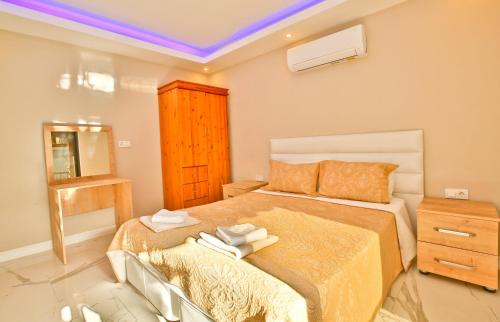 a bedroom with a large bed with a yellow bedspread at Nur Suites & Hotels in Kalkan
