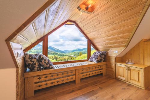 a window seat in a cabin with a view of the mountains at Salaš Syrex in Zázrivá