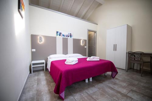 a bedroom with a bed with a pink blanket at Le PALME in Parma