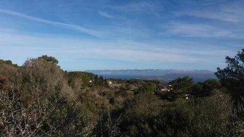 a view of the ocean from a hill with trees at Villetta panoramica con vista mare in Carloforte