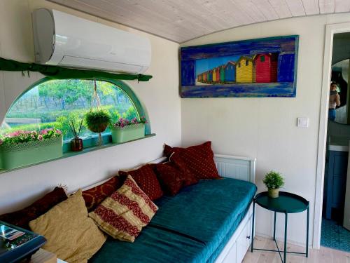 a living room with a couch and a window at Bohemian Eco Lodge at lake Balaton in Kisapáti