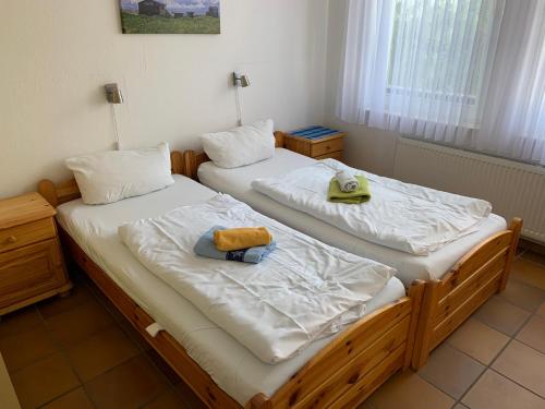 two twin beds in a room with towels on them at Frisiastraße 21 in Norderney