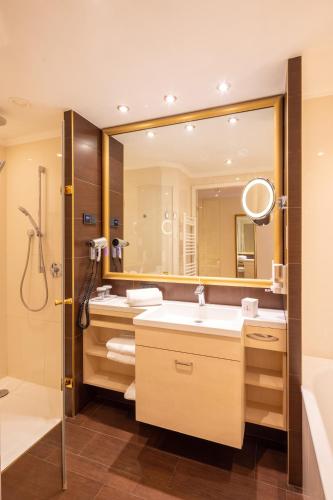 a bathroom with a sink and a mirror at Hotel Schlosskrone in Füssen