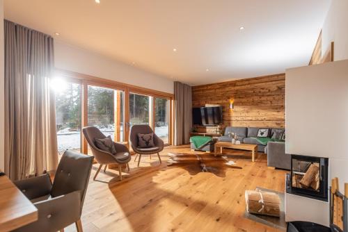 a living room with a couch and chairs at Luxury Chalets Gradenbach near Schladming in Haus im Ennstal