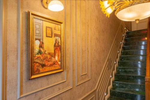 a hallway with paintings on the wall and stairs at Begonville Mansion Oldcity in Istanbul