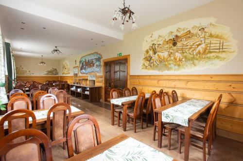 uma sala de jantar com mesas e cadeiras de madeira em U Haliny em Biały Dunajec