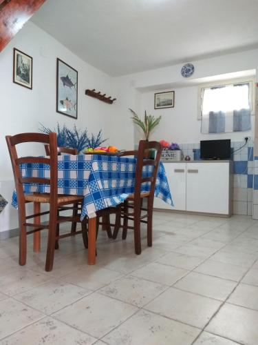 a dining room table with chairs and a blue and white table cloth at Villetta panoramica con vista mare in Carloforte