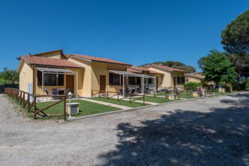 a house with tables and chairs in front of it at I SEE LAKE in Castiglione del Lago