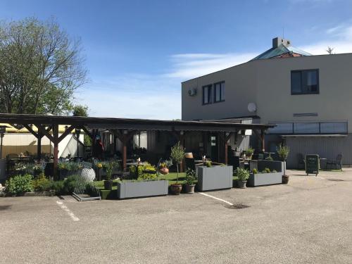 a building with a bunch of potted plants in a parking lot at Pension Pegast in České Budějovice