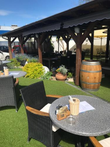 a table and chairs on a lawn with a barrel at Pension Pegast in České Budějovice