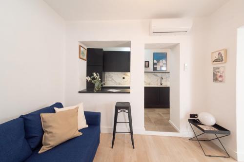 a living room with a blue couch and a stool at Casa Miguel - Apartamento 4 in Sanlúcar de Barrameda
