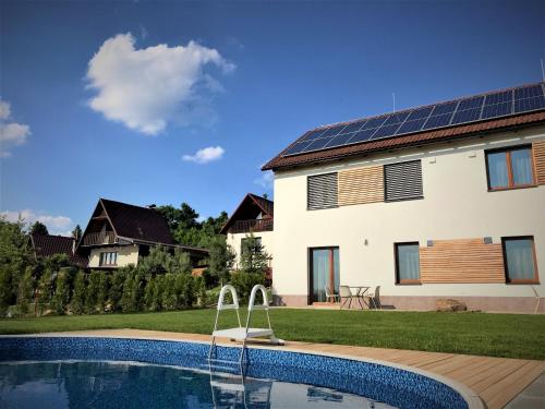 ein Haus mit einem Pool und einem Haus mit Sonnenkollektoren in der Unterkunft Apartmán Svárov in Nové Město na Moravě