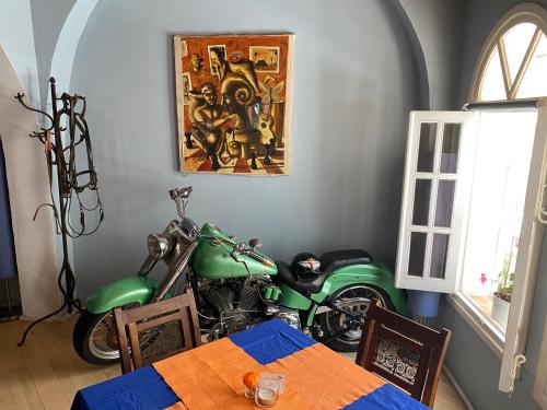 a green motorcycle parked in a room with a table at El Chili Boutique Hotel in Barbate