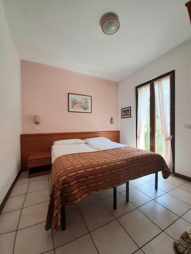 a bedroom with a bed and a window at Appartamenti Elisabeth in Brenzone sul Garda