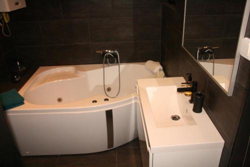 y baño con bañera blanca y lavamanos. en Smart Apartments en Budapest