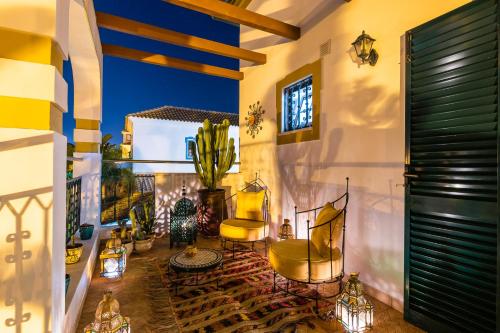 a balcony with two yellow chairs and a cactus at Riad Serpa Galé - Luxury, private pool, AC, wifi, 5 min from the beach in Guia